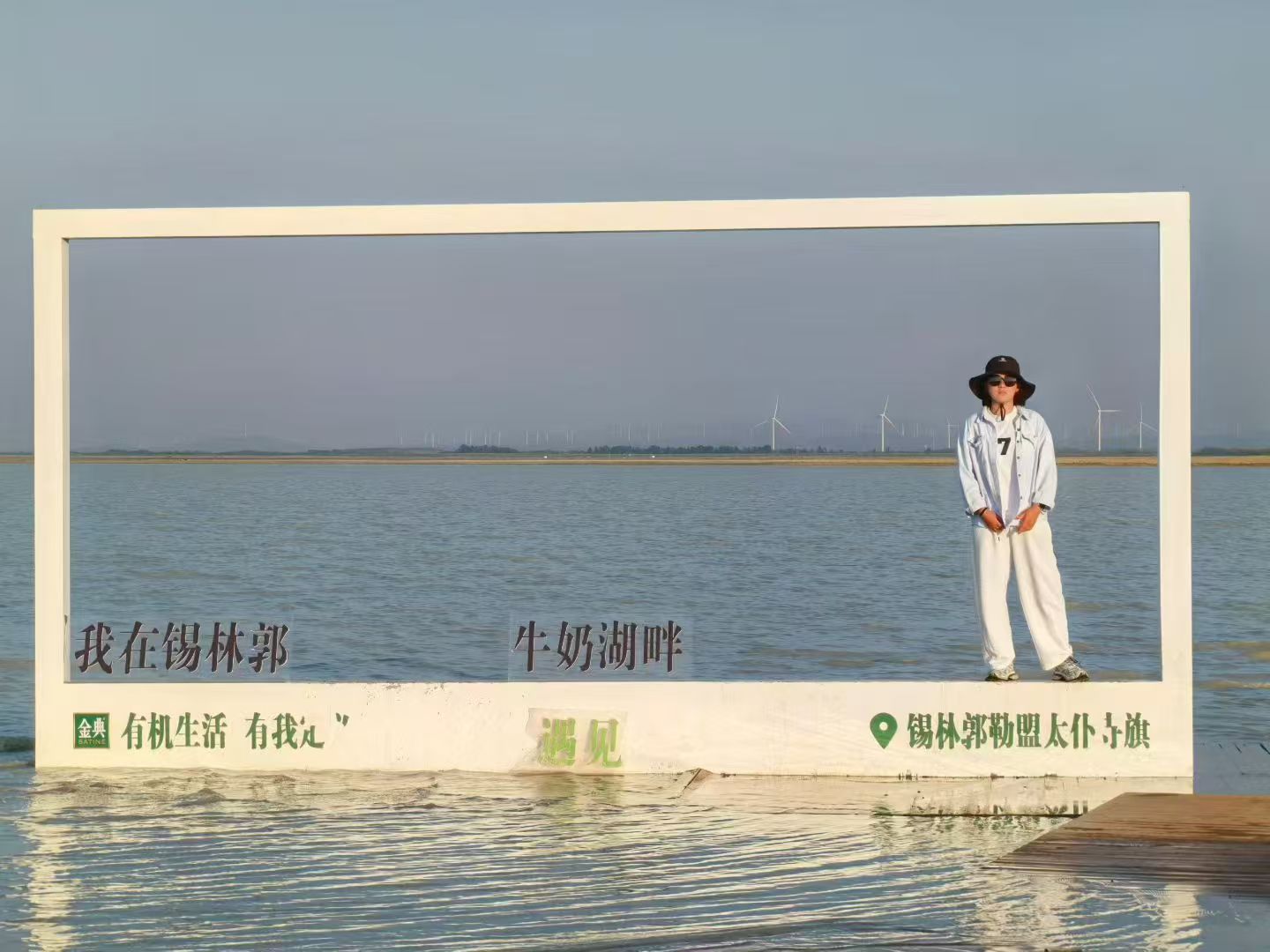 郜津阅站在牛奶湖畔的巨大相框里